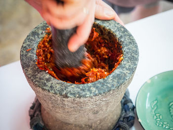 Close-up of person making curry paste in mortar