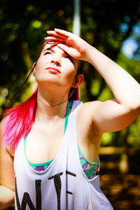 Young woman shielding eyes at park