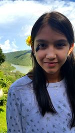 Portrait of young woman against sky