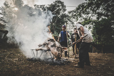 People on swing against trees