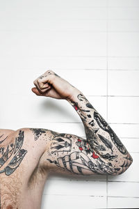 Cropped shot of a tattooed man flexing bicep