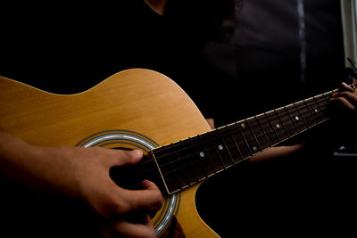 Midsection of man playing guitar