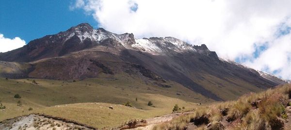 Scenic view of mountains against cloudy sky
