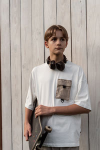 Portrait of young man standing against wall