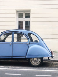 Vintage car parked on street against building