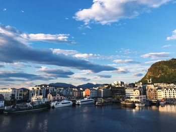 Buildings by river against sky in city