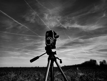 Low angle view of vintage film camera on field against sky