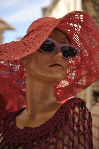 Close-up portrait of young woman wearing sunglasses against sky