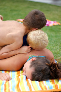 Children lying on mother at park