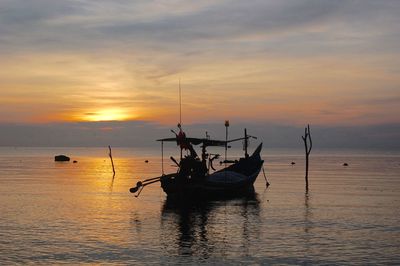 Silhouette boat in sea against sky during sunset