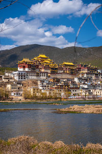 Buildings by town against sky