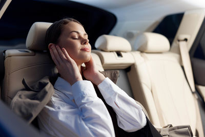 Portrait of young woman sitting in car