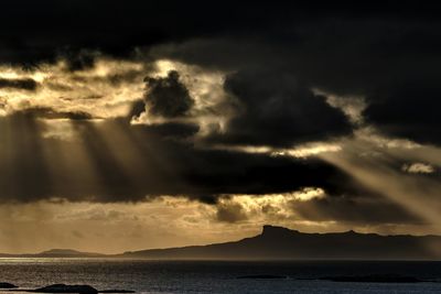 Scenic view of sea against dramatic sky during sunset