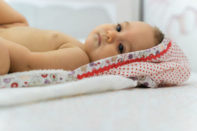 Portrait of cute baby lying on bed