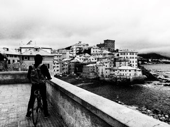 Rear view of man standing on city against sky