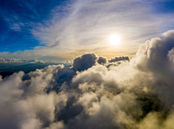 Low angle view of sunlight streaming through clouds