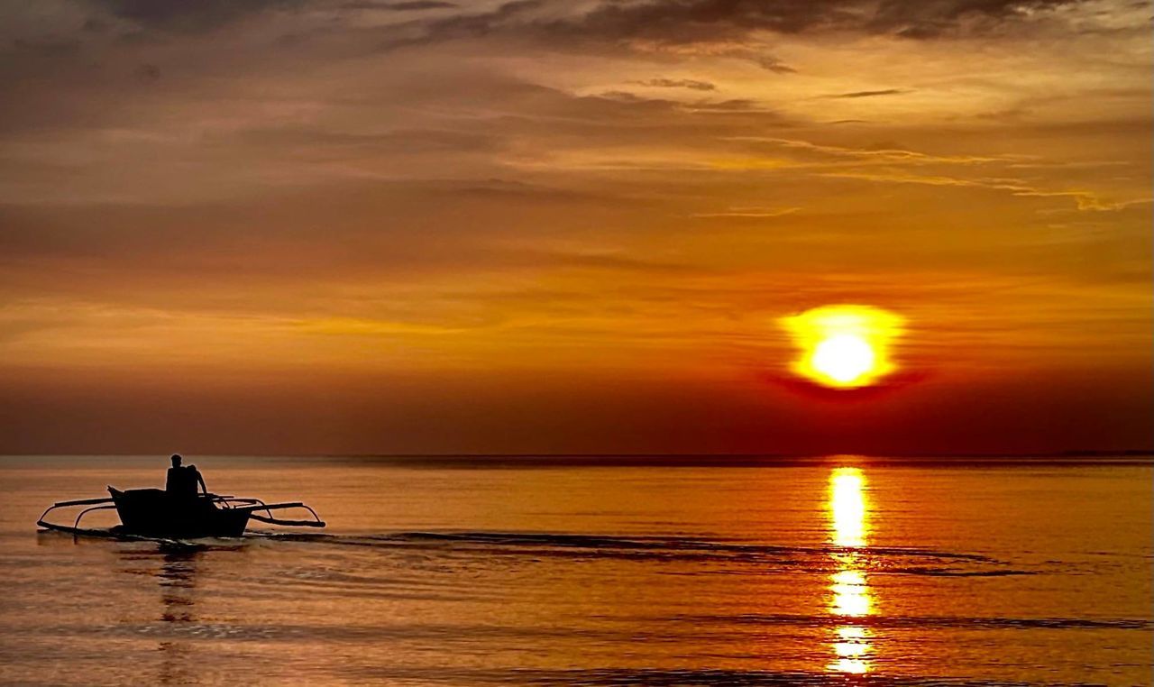 water, sunset, sky, sea, nautical vessel, transportation, beauty in nature, horizon, cloud, nature, reflection, afterglow, scenics - nature, silhouette, mode of transportation, sun, dawn, orange color, tranquility, horizon over water, evening, travel, tranquil scene, sunlight, shore, dramatic sky, ocean, travel destinations, idyllic, outdoors, vacation, environment, one person, beach, trip, holiday, seascape, land, boat, vehicle, men, relaxation, occupation, tourism, motion, landscape, sailing, wave