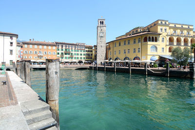 Canal passing through buildings against clear sky