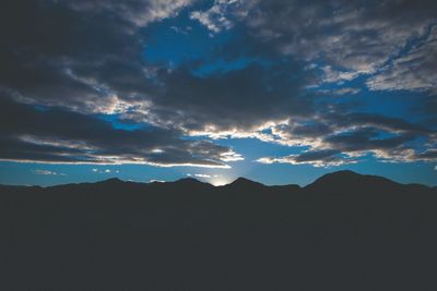 Scenic view of mountains against cloudy sky