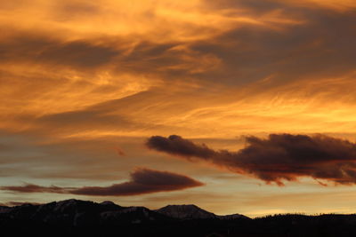 Scenic view of dramatic sky over silhouette landscape