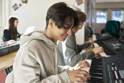 Teenagers attending keyboard lesson