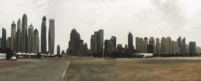 Modern buildings in city against cloudy sky