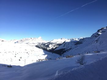 Scenic view of snowcapped mountains against blue sky