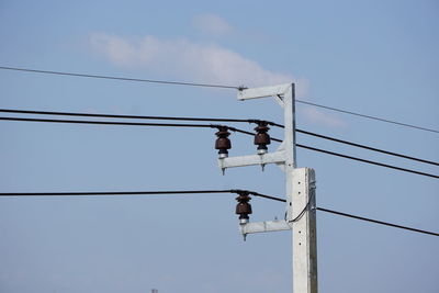 Low angle view of bird on pole against sky