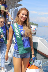 Portrait of happy woman in boat against sea