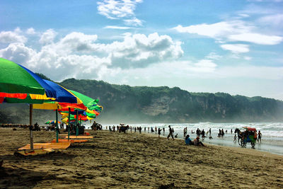 People at beach against sky