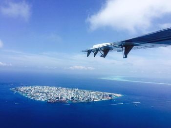 Airplane flying over sea against sky