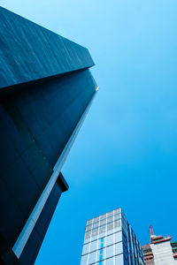 Low angle view of modern building against clear blue sky