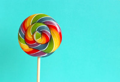 Low angle view of multi colored umbrella against blue background