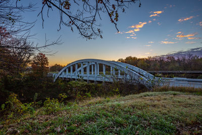 Bridge over river against sky during sunset