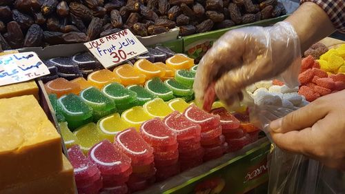 Midsection of woman with fruits for sale at market stall