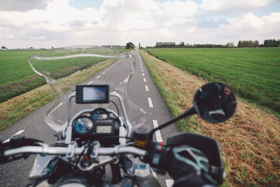 Cropped image of person riding motorcycle on road