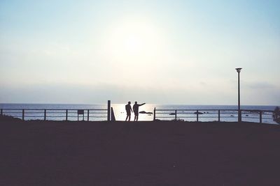 Silhouette people on calm beach