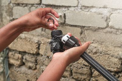 Close-up of hand holding camera against wall