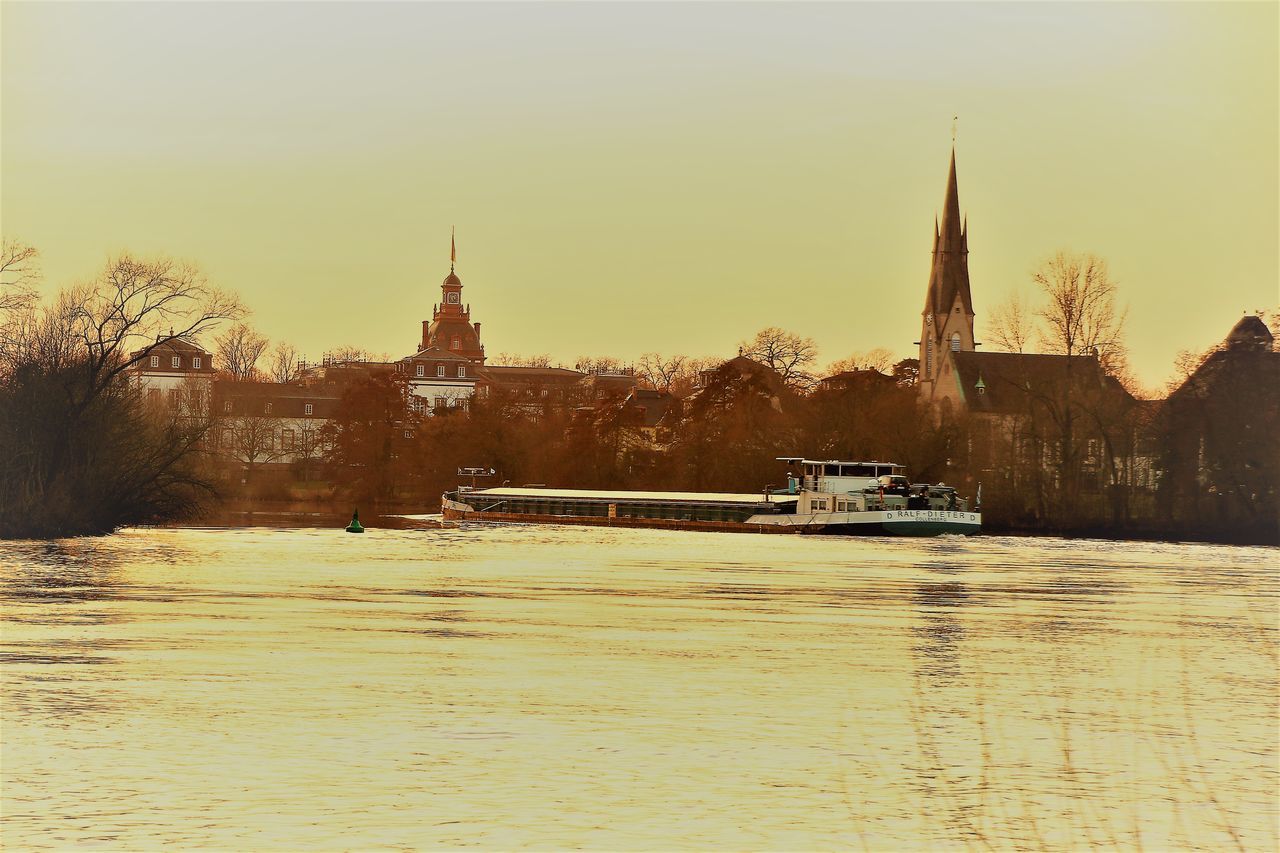 BOATS IN RIVER BY CATHEDRAL AGAINST SKY