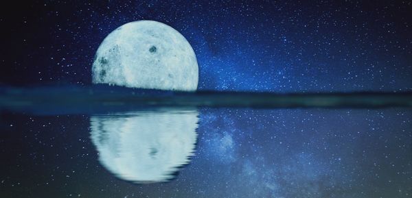 Scenic view of lake against sky at night