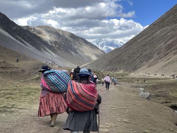 Rear view of people walking on mountain