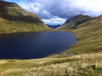 Scenic view of mountains and lake against cloudy sky