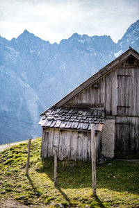 Abandoned house by mountains against sky