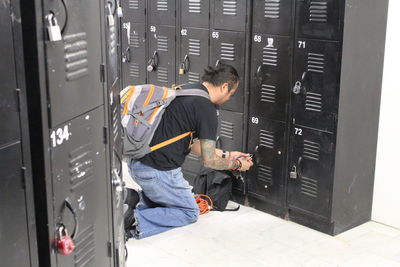 Side view of backpacker opening locker