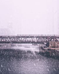 Bridge over river against sky during winter