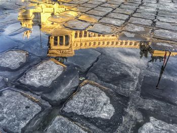 Reflection of building in puddle on street