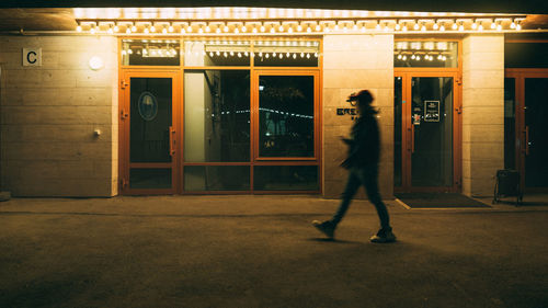 Full length of a man walking on illuminated city at night