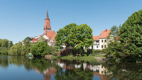 Scenic view of lake by buildings against sky