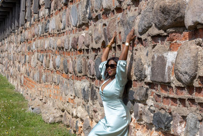 Full length of woman standing on stone wall