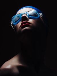 Female swimmer against black background